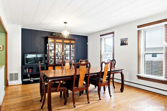 a dining room with furniture window and wooden floor