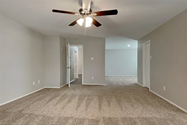 an empty room with closet and a chandelier fan