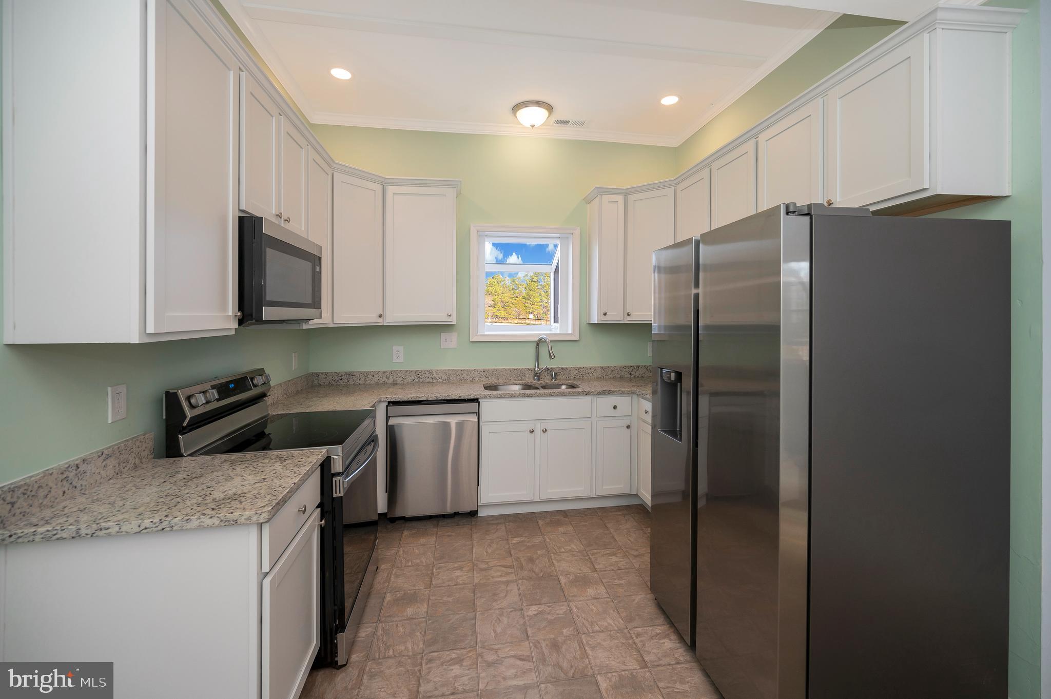 26348 Sunshine Road Ruther Glen, VA 22546 - Photo 17 of 56 a kitchen with a refrigerator and a sink