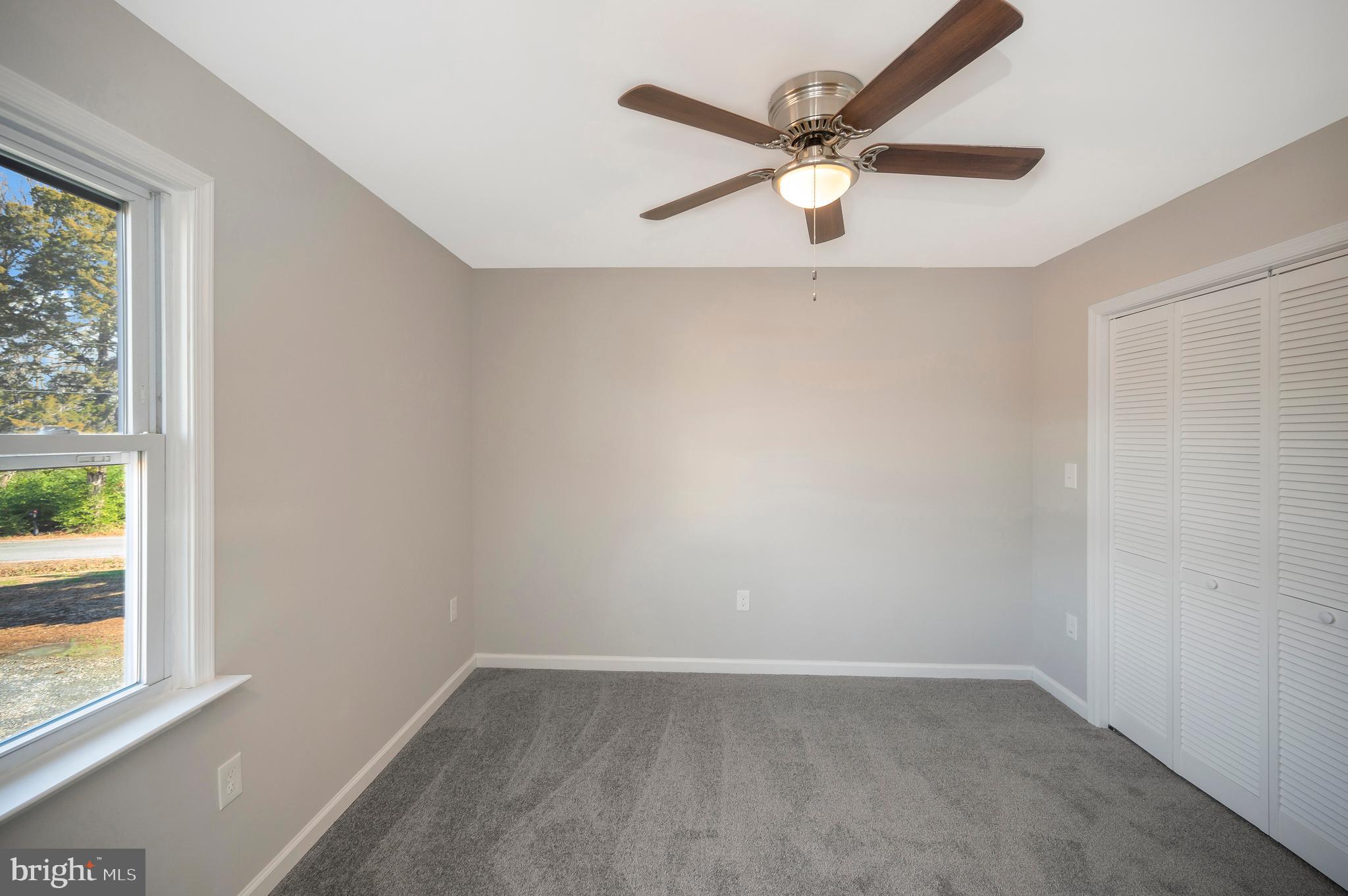 26348 Sunshine Road Ruther Glen, VA 22546 - Photo 34 of 56 an empty room with a window and a ceiling fan