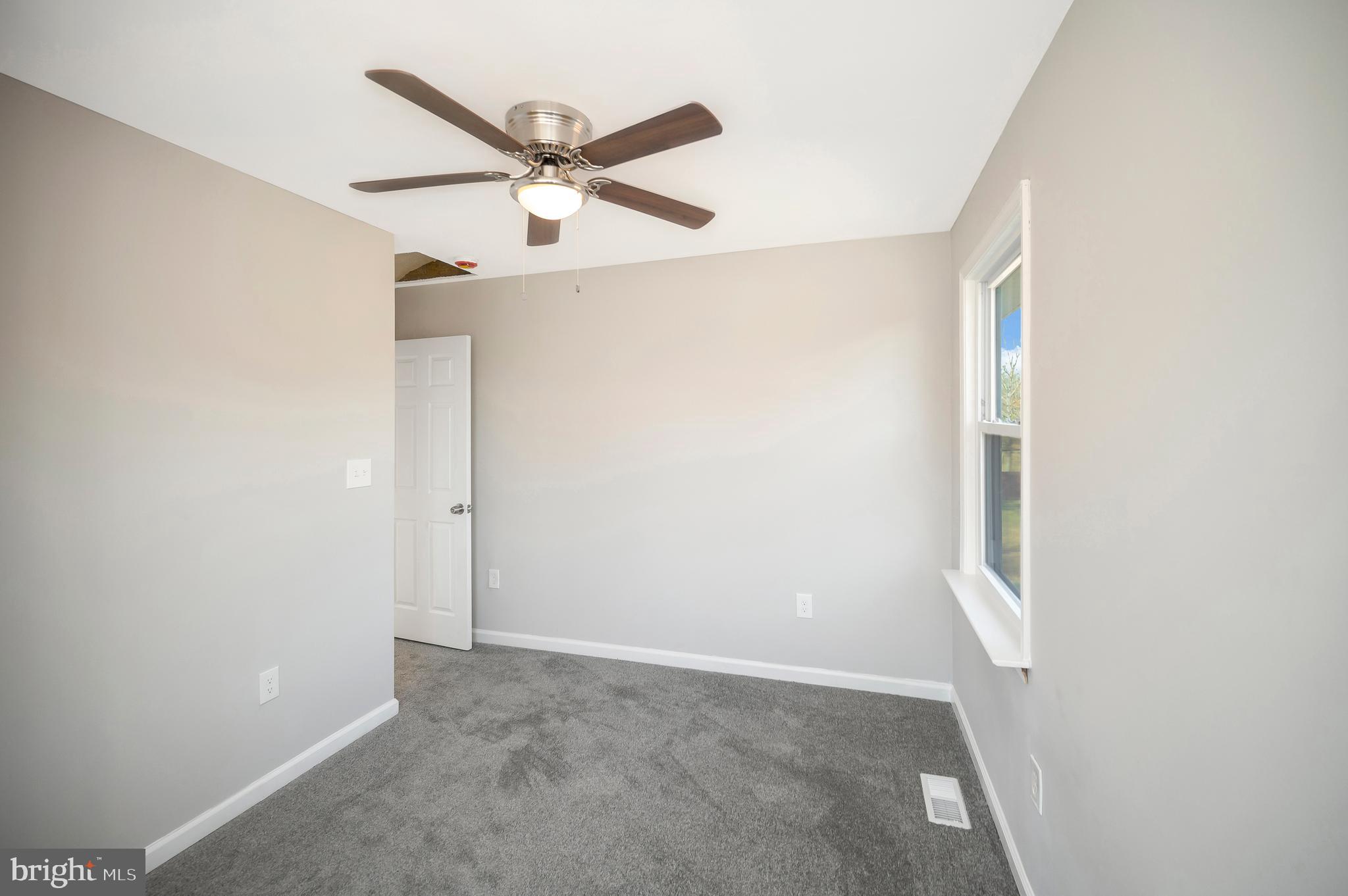 26348 Sunshine Road Ruther Glen, VA 22546 - Photo 40 of 56 an empty room with wooden floor and a ceiling fan