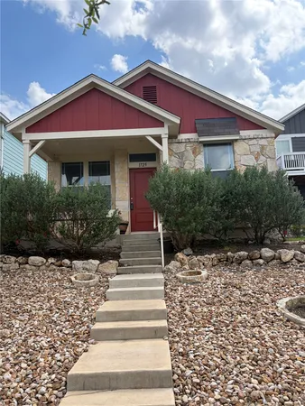 a front view of a house with plants
