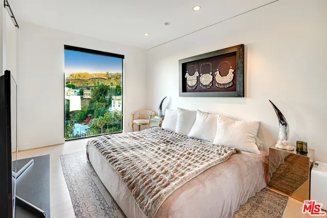 a bed sitting in a bedroom next to a window