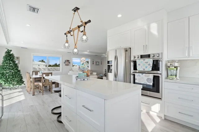 a kitchen with stainless steel appliances kitchen island granite countertop a refrigerator and microwave