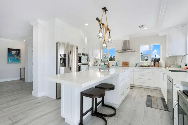 a kitchen with stainless steel appliances a sink cabinets and wooden floor