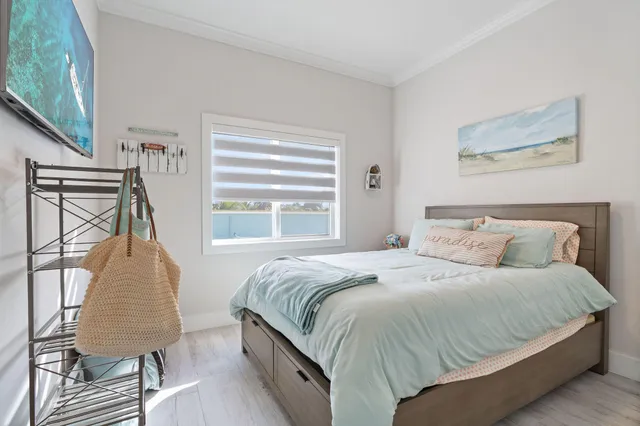 a bedroom with a bed a chair and a large window