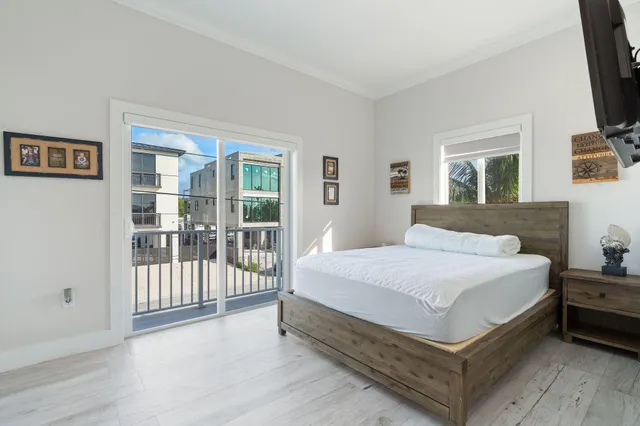 a bedroom with a bed a flat screen tv and balcony