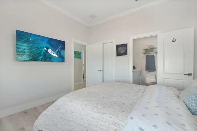 a bedroom with a large bed and a painting on the wall