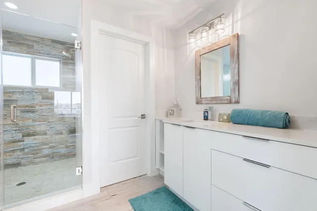 a bathroom with a double vanity sink mirror and shower