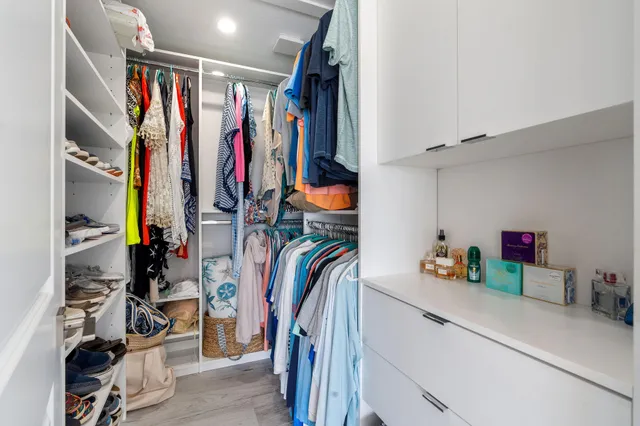 a view of walk in closet with clothes and shoes