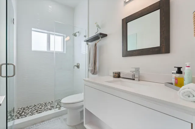 a bathroom with a granite countertop sink a toilet and a mirror