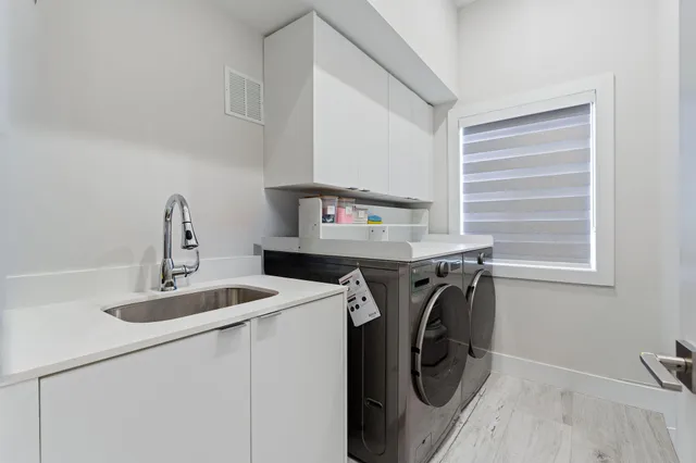 a utility room with sink dryer and washer