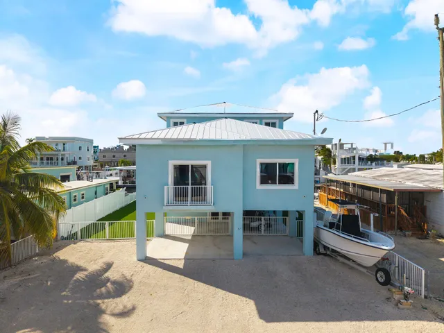 a view of a house with a backyard and a patio