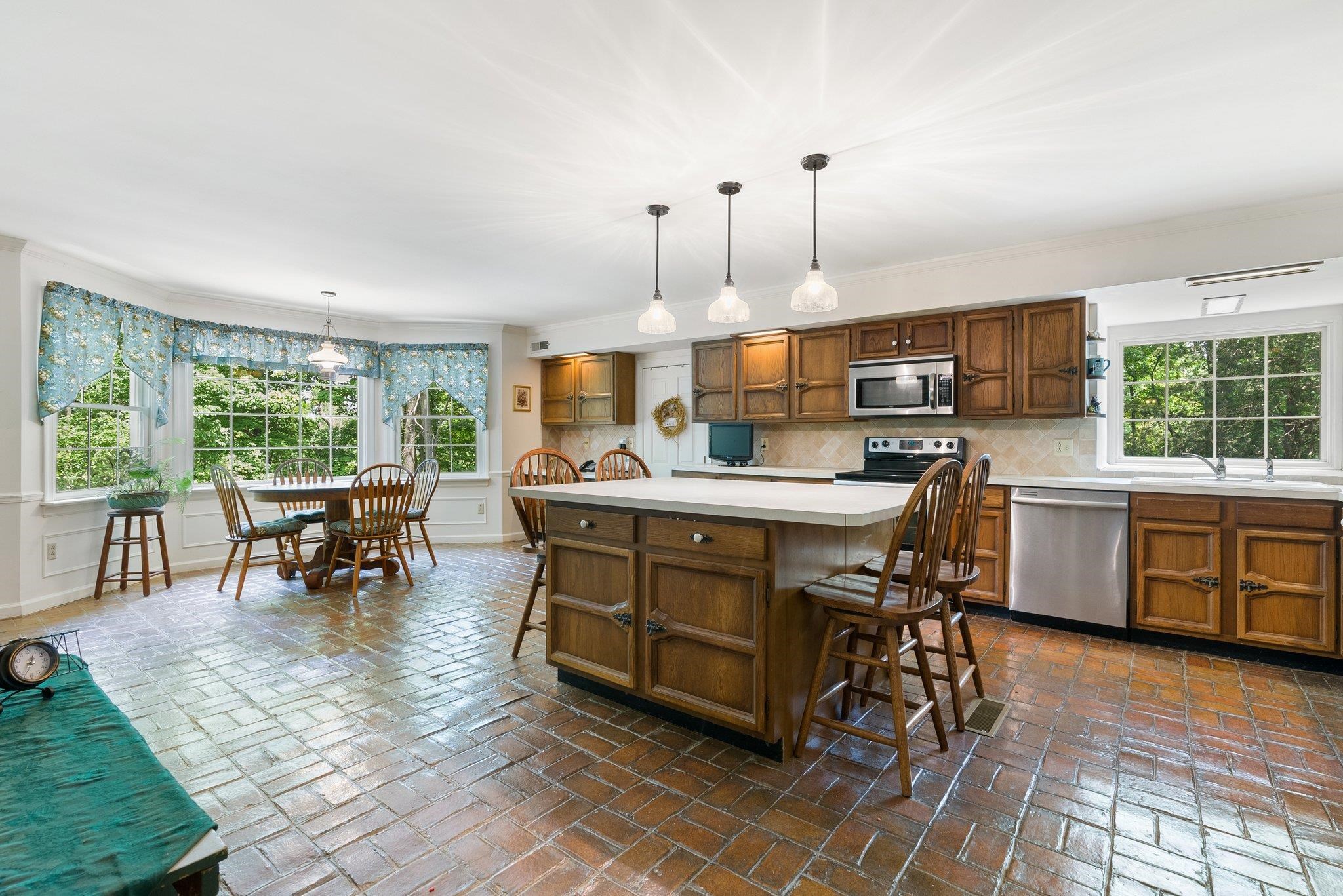 88 Roman Ridge Road Mount Sidney, VA 24467 - Photo 33 of 74 a kitchen with kitchen island granite countertop a table chairs sink and cabinets