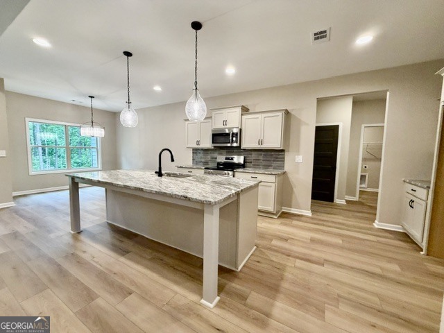 264 Robert Williams Road Greenville, GA 30222 - Photo 6 of 23 a kitchen with stainless steel appliances granite countertop a sink a stove and a wooden floor