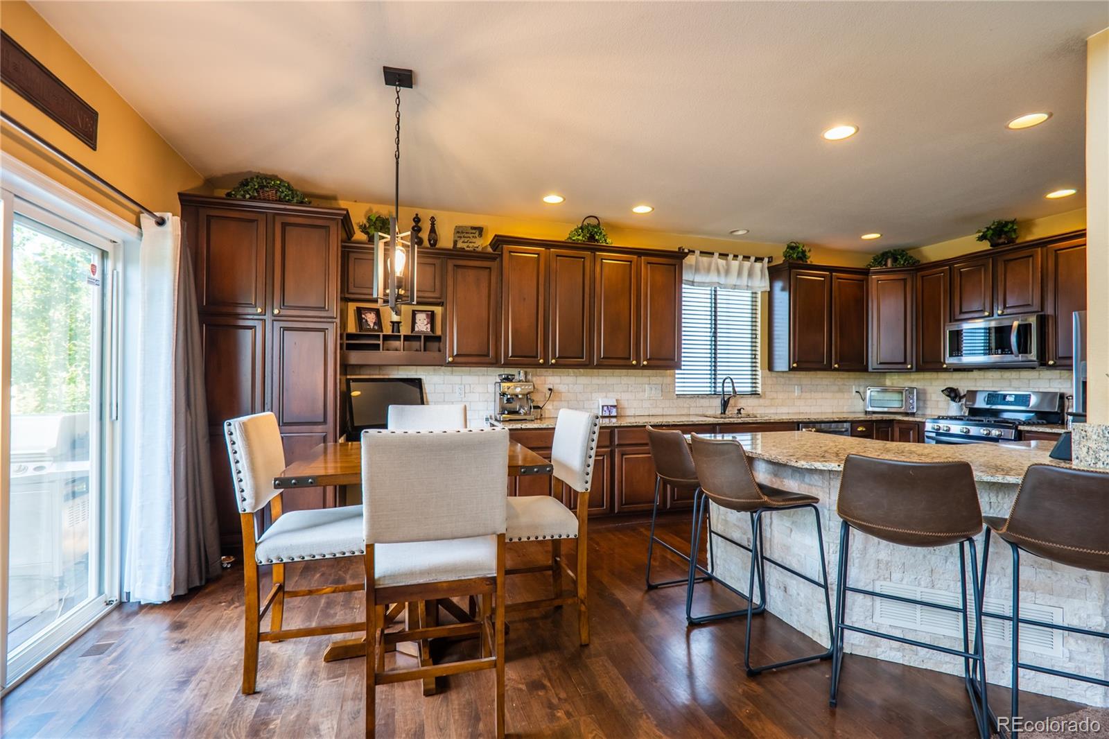 10857 Hickory Ridge Street Highlands Ranch, CO 80126 - Photo 12 of 40 a dining room with furniture a chandelier and wooden floor