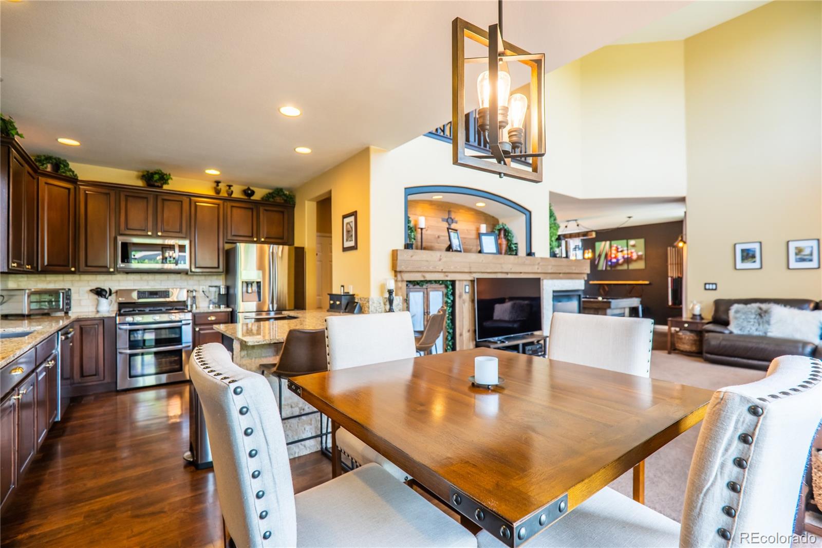 10857 Hickory Ridge Street Highlands Ranch, CO 80126 - Photo 13 of 40 a living room with stainless steel appliances furniture a fireplace a rug and a kitchen view