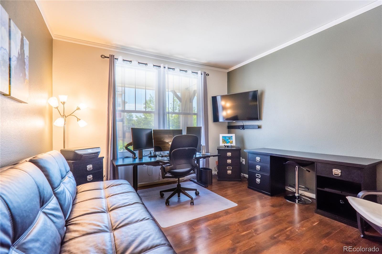 10857 Hickory Ridge Street Highlands Ranch, CO 80126 - Photo 6 of 40 a living room with furniture and a flat screen tv