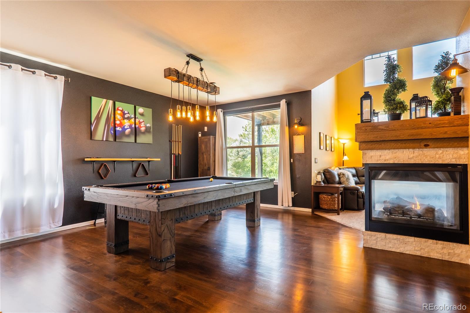 10857 Hickory Ridge Street Highlands Ranch, CO 80126 - Photo 8 of 40 a living room with furniture a fireplace and a flat screen tv
