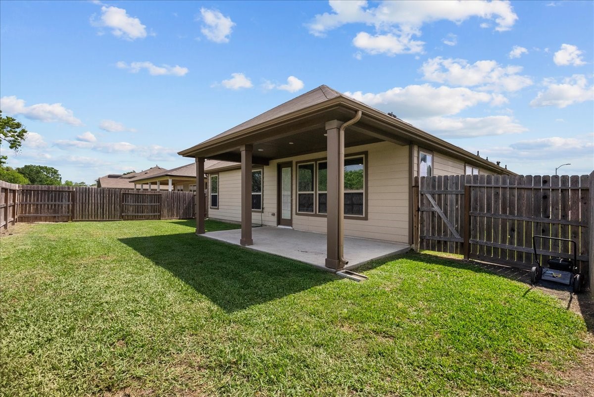 2320 Rosemary Street Rosenberg, TX 77469 - Photo 37 of 40 This photo showcases a cozy backyard with a covered patio, perfect for outdoor relaxation. The space is enclosed by a wooden fence, offering privacy and a safe area for children or pets.
