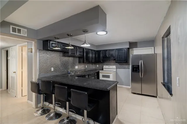 a kitchen with stainless steel appliances granite countertop a sink a stove and a refrigerator