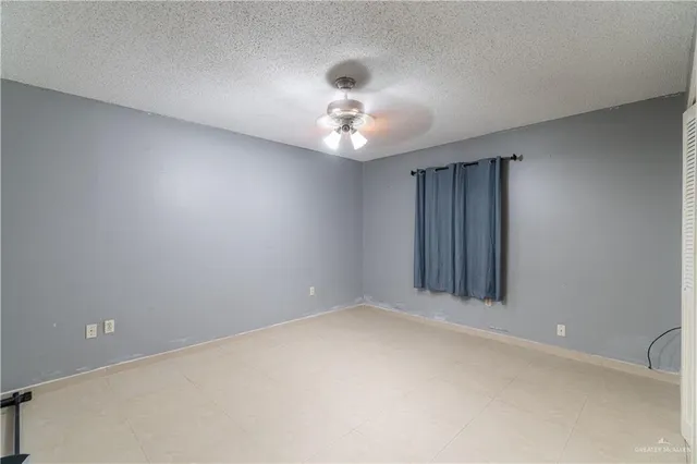 an empty room with a ceiling fan and a window