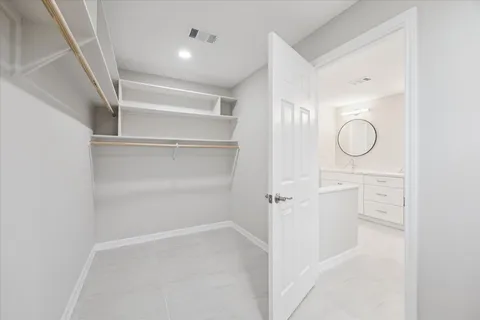 a view of walk in closet with empty racks