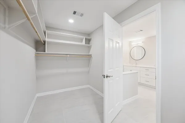 a view of walk in closet with empty racks
