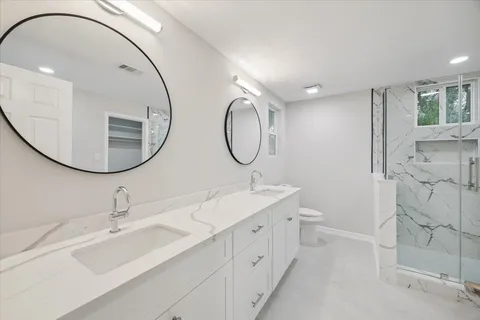 a bathroom with a double vanity sink mirror and bathtub