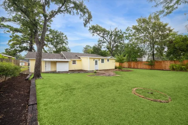 a view of a house with backyard and a tree