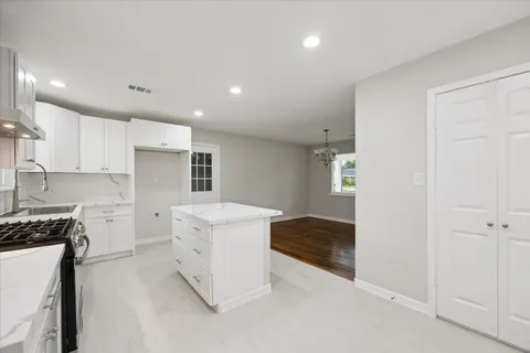 a kitchen with a stove and white cabinets