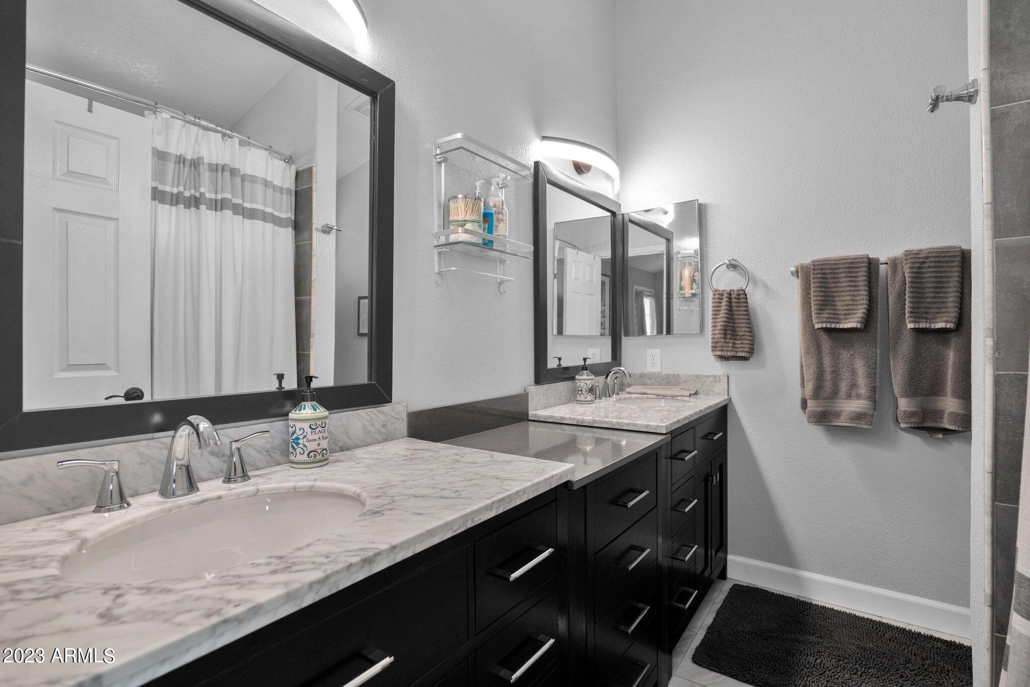 4338 East Douglas Avenue Gilbert, AZ 85234 - Photo 18 of 48 a bathroom with a granite countertop double vanity and a mirror