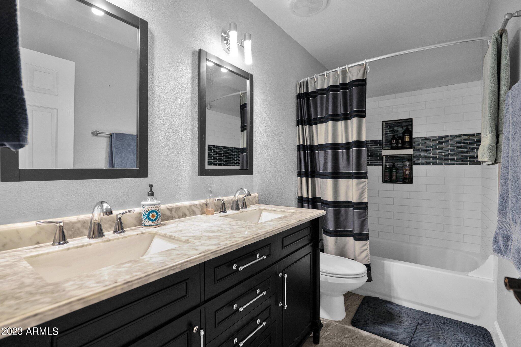 4338 East Douglas Avenue Gilbert, AZ 85234 - Photo 22 of 48 a bathroom with a granite countertop sink a large mirror a toilet and shower