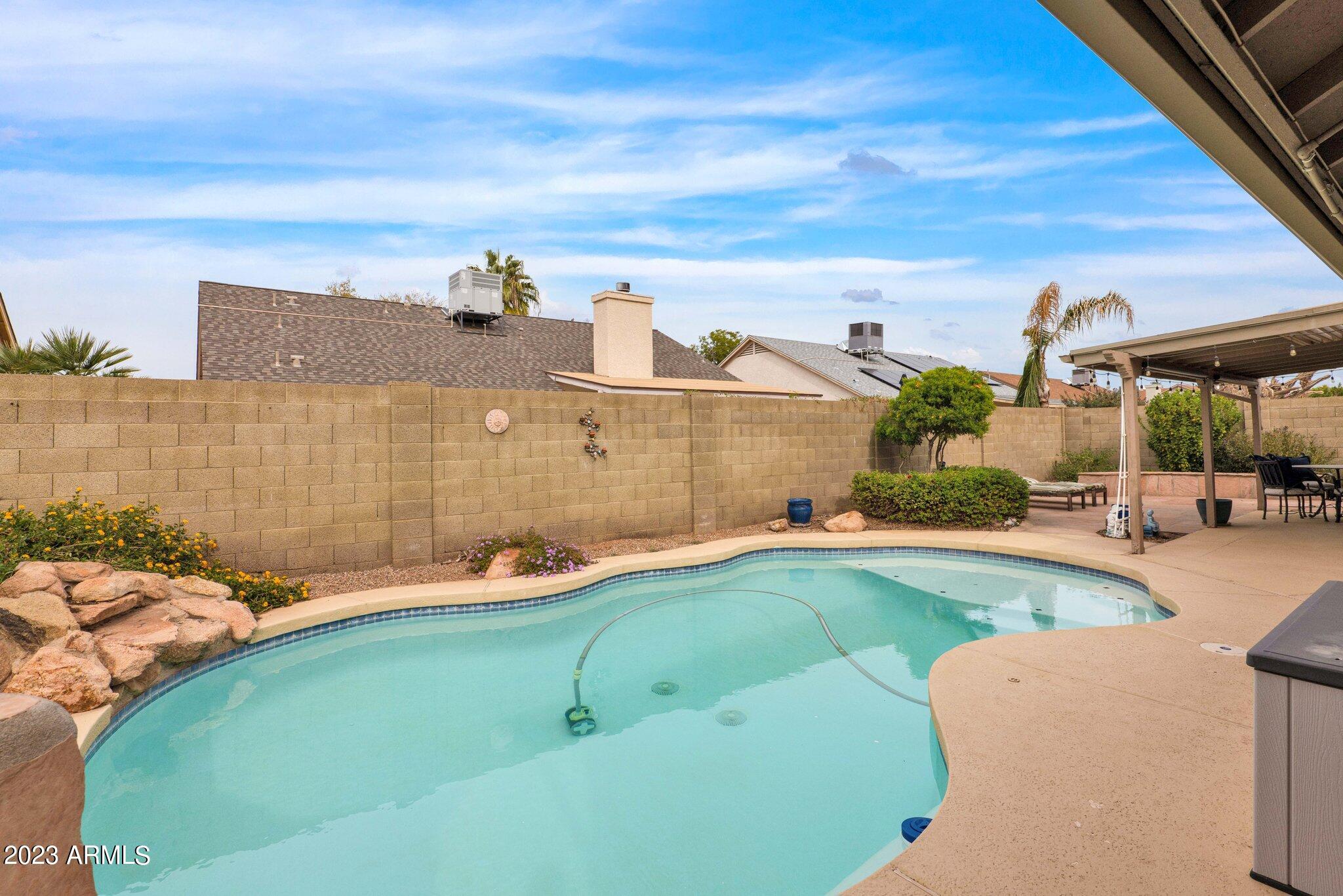 4338 East Douglas Avenue Gilbert, AZ 85234 - Photo 32 of 48 a swimming pool with outdoor seating and barbeque oven