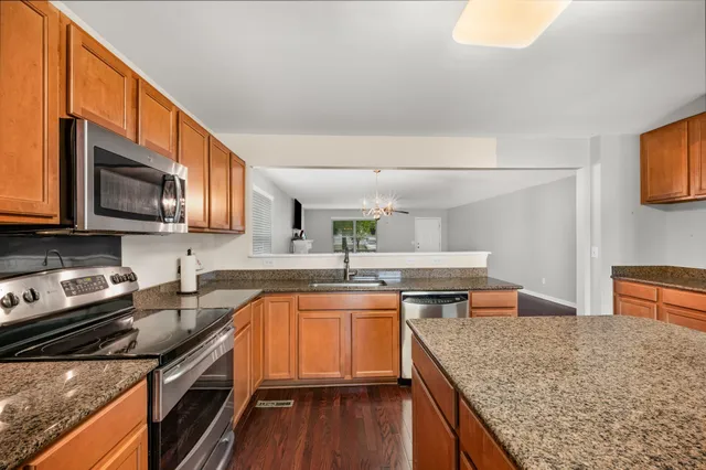 a kitchen with stainless steel appliances granite countertop a sink stove and microwave