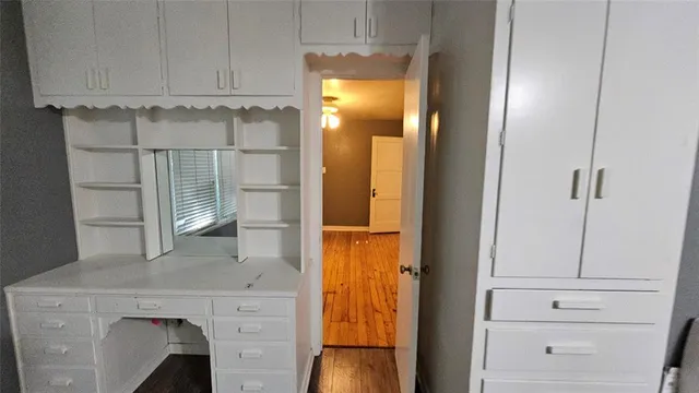 a view of walk in closet with white cabinet and door