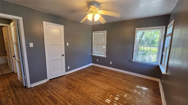 a view of empty room with window and wooden floor
