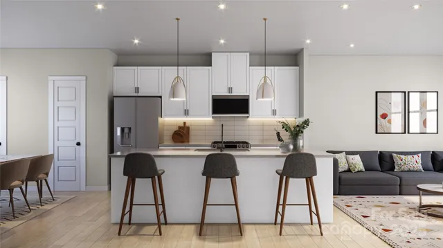 a living room with stainless steel appliances kitchen island a table and chairs