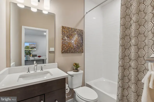 a bathroom with a sink a toilet a mirror a vanity and bathtub
