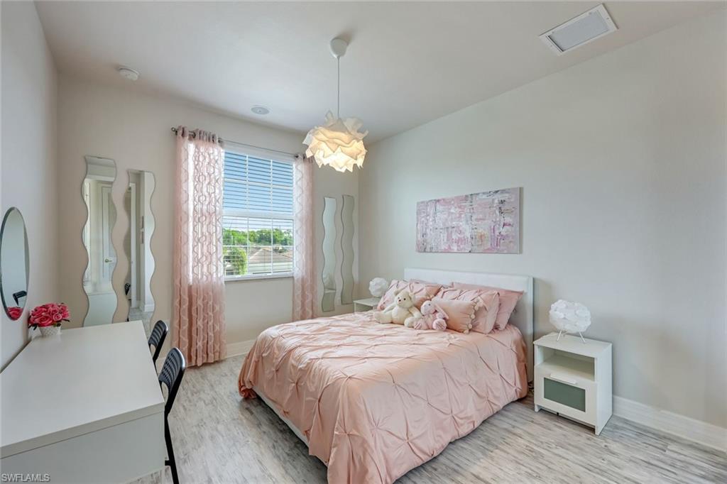 6582 Monterey Point Naples, FL 34105 - Photo 19 of 27 a bedroom with a bed and a chandelier