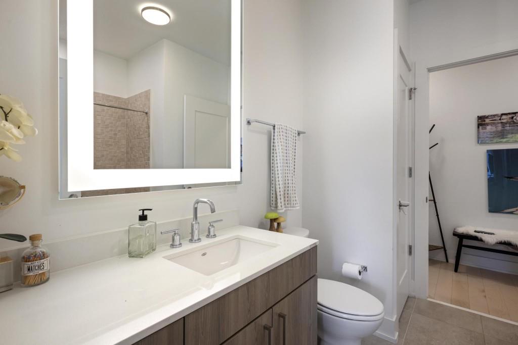 775 Juniper Street Northeast, Unit 602 Atlanta, GA 30308 - Photo 22 of 40 a bathroom with a toilet a sink a mirror and a bathtub