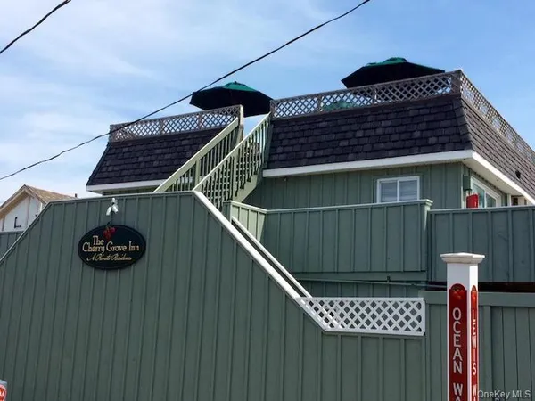 a roof deck with table and chairs under an umbrella