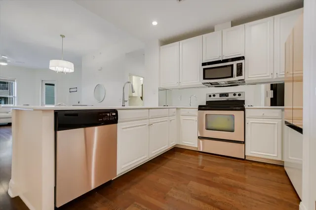 a kitchen with white cabinets stainless steel appliances and sink