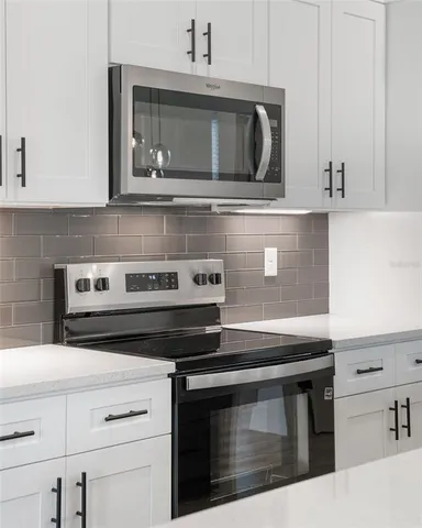 a kitchen with stainless steel appliances granite countertop a stove microwave and oven