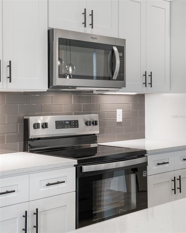 24419 Southwest Kingsway Circle Punta Gorda, FL 33983 - Photo 15 of 51 a kitchen with stainless steel appliances granite countertop a stove microwave and oven