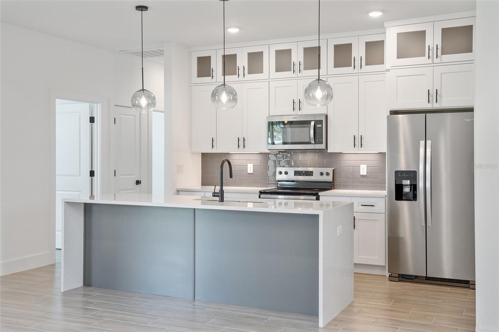 24419 Southwest Kingsway Circle Punta Gorda, FL 33983 - Photo 18 of 51 a kitchen with stainless steel appliances granite countertop a refrigerator a stove a sink and a microwave