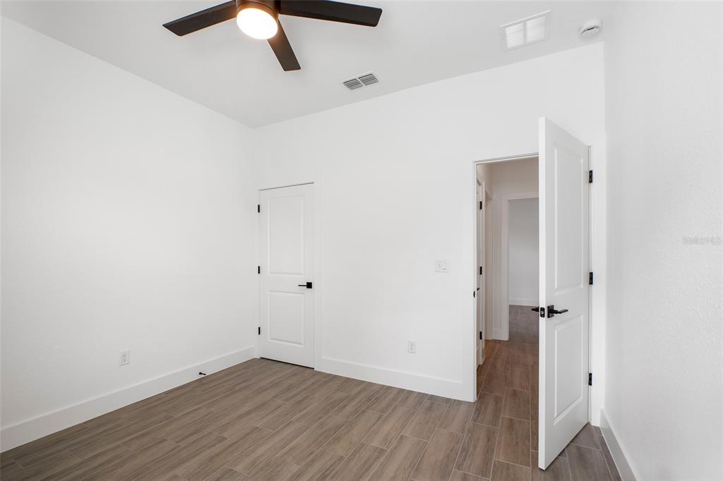 24419 Southwest Kingsway Circle Punta Gorda, FL 33983 - Photo 26 of 51 an empty room with wooden floor and chandelier fan