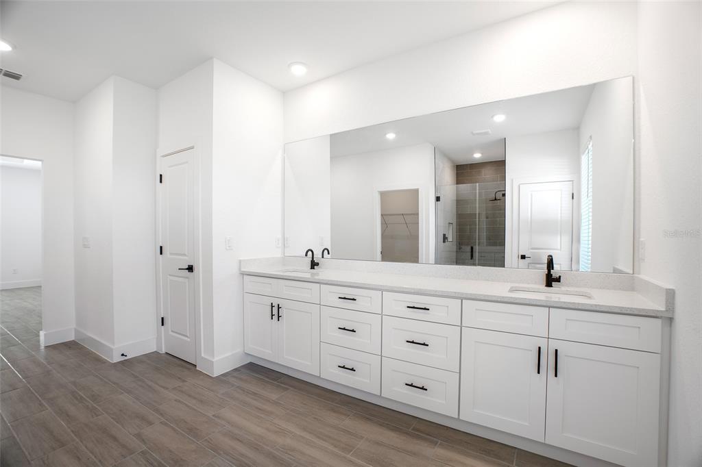 24419 Southwest Kingsway Circle Punta Gorda, FL 33983 - Photo 40 of 51 a spacious bathroom with double vanity a mirror and a bathtub