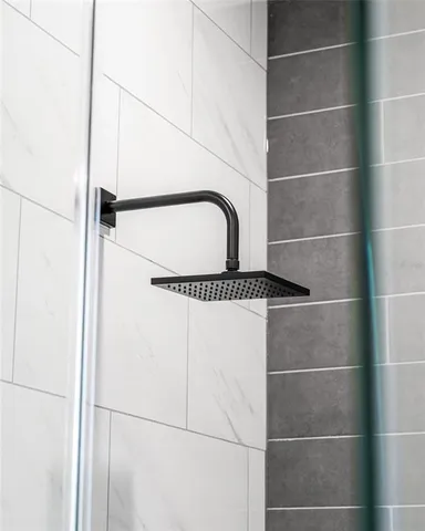 a close view of a glass door shower a sink and a window