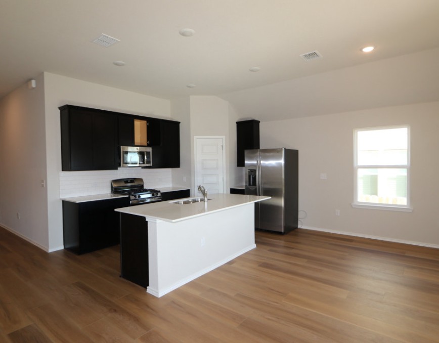 11905 Dillon Fls Drive Austin, TX 78747 - Photo 2 of 9 a kitchen with stainless steel appliances and wooden floor